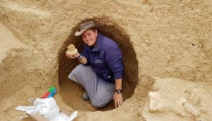 הארכיאולוגית שירה בלוך מחזיקה פך בן 2000 שנמצא בחפירה. צילום: רשות העתיקות